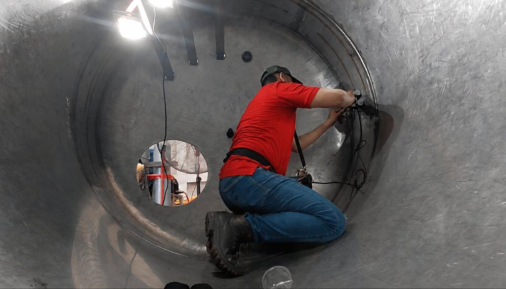 Inspector END trabajando dentro de tanque metálico